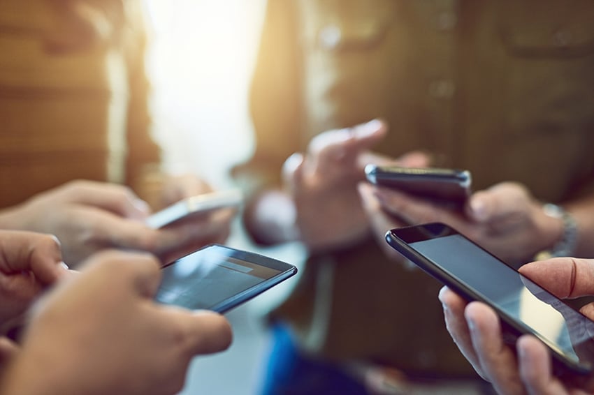 Group of people using smartphones in synchronicity .